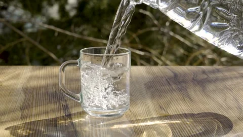 Refreshing Water Pouring into Mug, Windy Nature Background, 4K 120fps Stockbeeldmateriaal 330787149