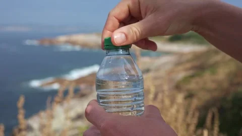 Refreshing Water: Woman's Hand Opens Clear Bottle. Health, and Relaxation Stock Footage 243845306