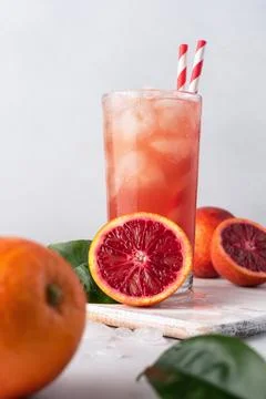 Refreshment iced drink. Red or blood Sicilian orange juice in a glass and fre Stock Photos