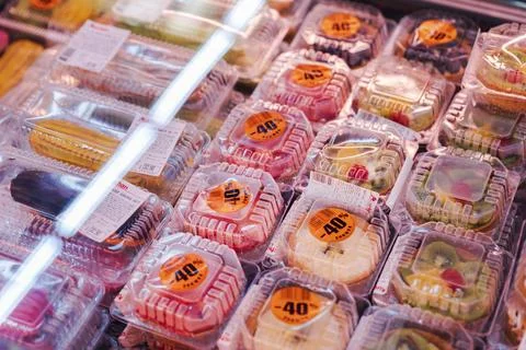 Refrigerated Display Case with Various Fruit Tarts and Cakes in a Supermarket Stock Photos