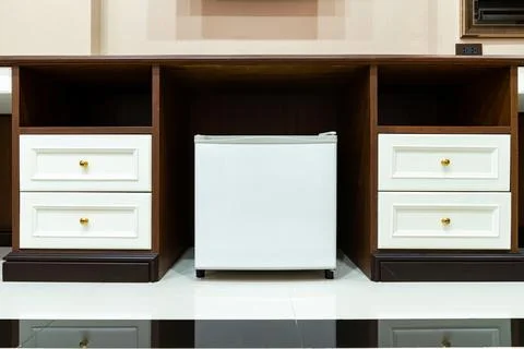 Refrigerator fridge mini size under the table counter with wooden desk besi.. Stock Photos