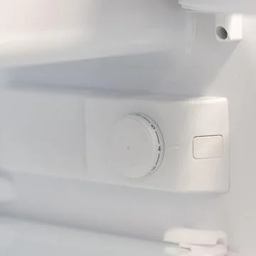Refrigerator temperature control dial inside white appliance Stock Photos