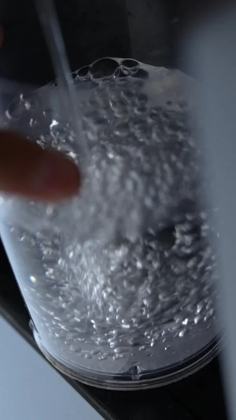 Refrigerator Water Stream Pouring into a Plastic Cup Creating Bubbles Stock Footage 304470348