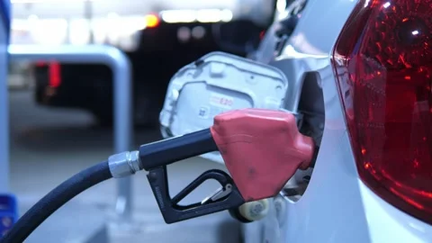 Refueling a silver car with a fuel nozzle at a gas station for energy, oil price 스톡 동영상 332299895