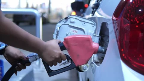 Refueling a silver car with a fuel nozzle at a gas station for energy, oil price 스톡 동영상 332299900
