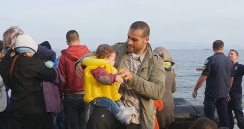 A refugee and his child after having crossed the sea by dinghy, 4k Stock Footage