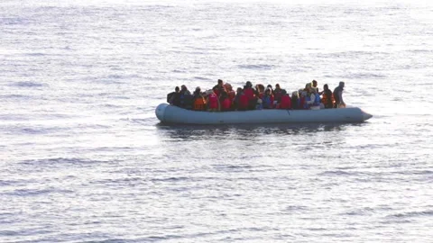 Refugee boat drifting without an enging on Lesbos with telefocus lense at da Stock Footage 145909505