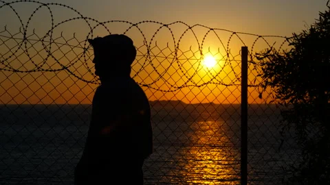 Refugee at the border at sunset Stock Footage 302874596
