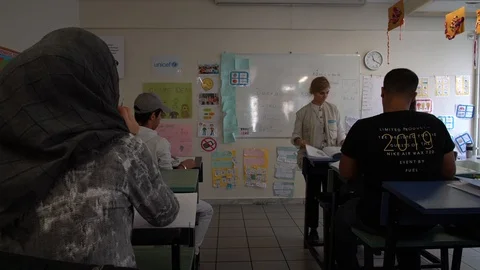 Refugee learning Greek in a class in Athens with the Elix NGO Stock Footage 119118682