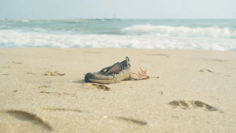Refugee shoe washed up on shoreline. Missing drowned Refugee body rescue mission Stock Footage 230494473