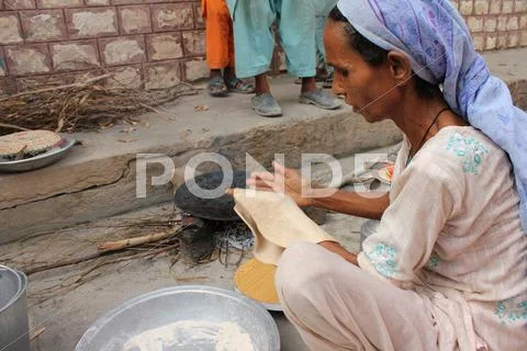 Refugee Woman Cooking Bread Stock Photos