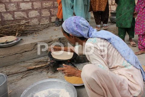 Refugee Woman Cooking Bread Stock Photos