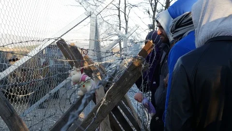 Refugees and migrants wait on the Greece-Macedonia border near Idomeni Vídeo Stock 99181685
