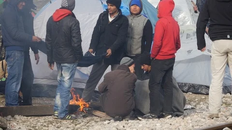 Refugees and migrants wait on the Greece-Macedonia border near Idomeni Stock-Footage 99181764