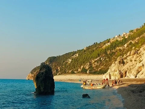 Refugees immigrants embark on a small boat on a wild beach trying to escape Stock Footage 80064588