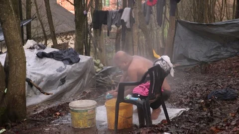 Refugess in Jungle camp taking shower Bosnia Stock Footage 194973087