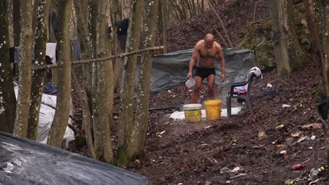 Refugess in Jungle camp taking shower Bosnia Stock Footage 194973092
