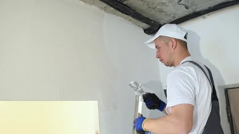 Refurbishment. Worker spackling a wall with putty Stock Footage 85398423