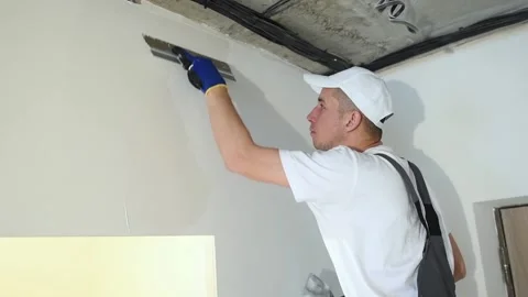 Refurbishment. Worker spackling a wall with putty Stock Footage 87540890
