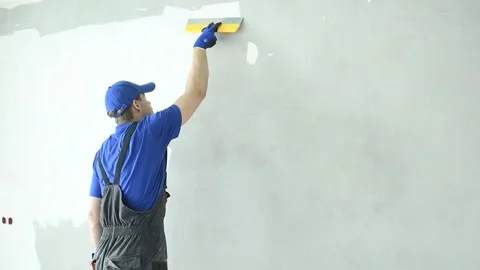 Refurbishment. Worker spackling a wall with putty Stock Footage 90895194