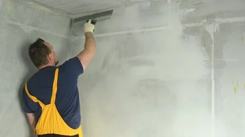 Refurbishment. Worker spackling a wall with putty Stock Footage 91056696