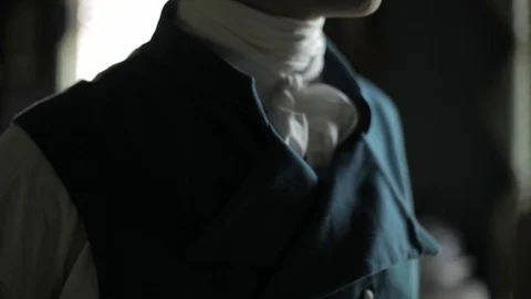 Regency-era man being dressed by another - formal dress coat being put on Stock Footage 100358749
