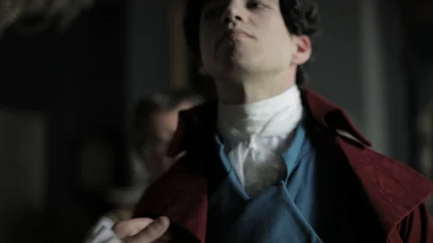 Regency-era man being dressed by another - formal dress, adding coat Stock Footage 100539173