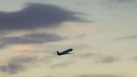 Regional jet ascending through a soft sunset sky Stock Footage 337795105