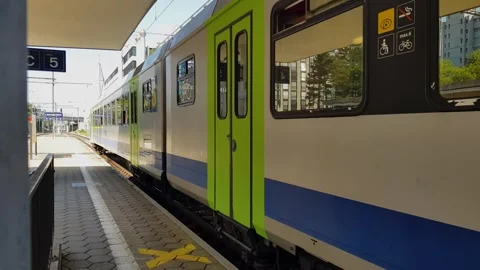 Regional train comes to a stop at Bümpliz Nord station and female passenger Stock Footage 295334257