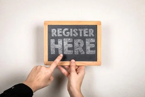 Register Here Message Written on Small Chalkboard Held by Hands Stock-Fotos