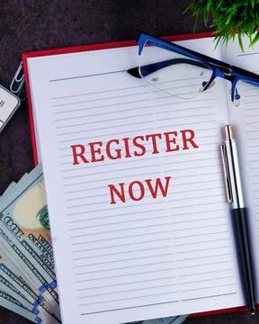 REGISTER NOW words written in a notebook, a vertical photo Stock Photos