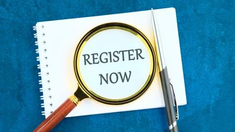 REGISTER NOW words written through the lens of a magnifying glass in a notebo Stock Photos