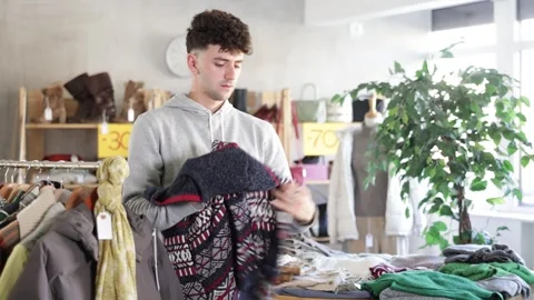 Regular customer guy chooses color and style sweater Stock Footage 327138007