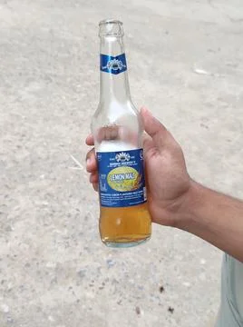 A regular drink called Lemon Malt in a male hand. Stock Photos