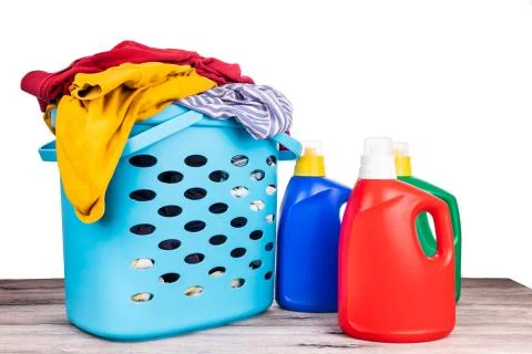 Regular laundry liquid detergent of various fragrance next to basket full of  Stock Photos