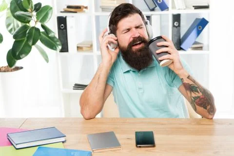 Regular office day. Man bearded guy headphones sit office listen music sing song Stock Photos