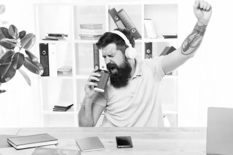 Regular office day. Man bearded guy headphones sit office listen music sing song Stock Photos