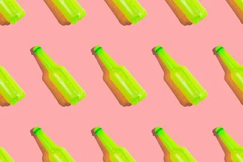 Regular pattern of acid yellow colored plastic bottles of drink on the pink Stock Photos
