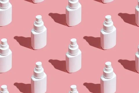 Regular Pattern of spray sanitizer tubes on the pink table flat lay. Fabric Stock Photos