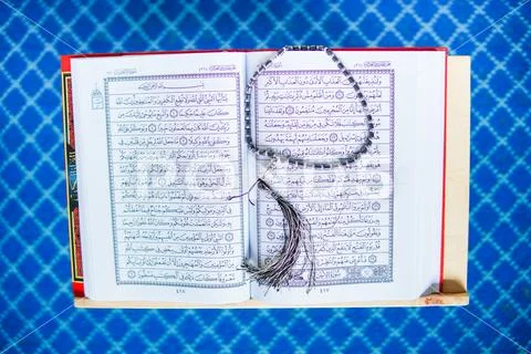 Rehal with open Quran and Muslim prayer beads inside a mosque Stock Photos