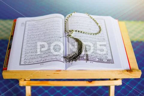 Rehal with open Quran and Muslim prayer beads inside a mosque Stock Photos