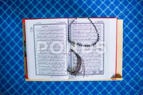 Rehal with open Quran and Muslim prayer beads inside a mosque Stock Photos