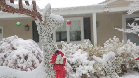 Reindeer decoration in front of house snow storm, tilt down Stock Footage