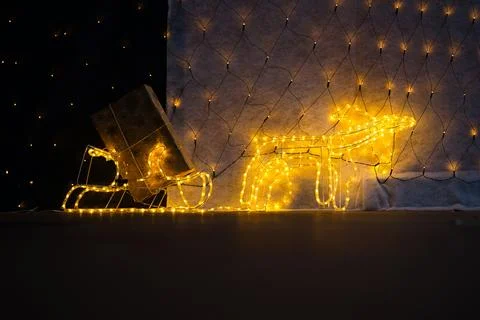 Reindeer Pulling Lighted Sled with Christmas Gift Stock Photos