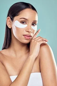 Reinvigorating my skin one patch at a time. a young woman using eye masks Stock Photos