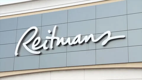 Reitmans logo sign on front of store with sky behind, close up Stock Footage 251371018