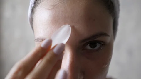 Rejuvenating hydration of the skin of the face of a young woman. Rubbing ice on Видео 120421854
