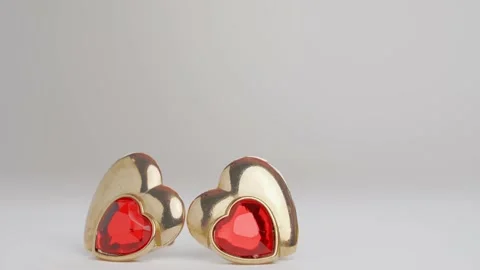 Relationship break up. Hand throws away golden heart shaped earring with ruby Stock Footage 225748917