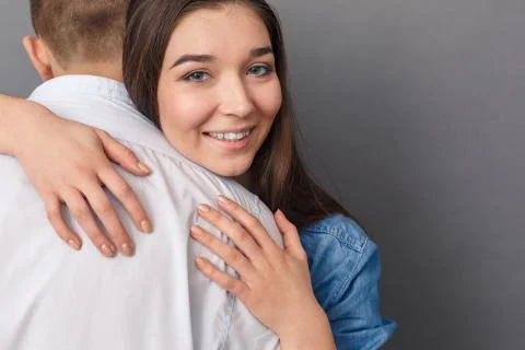 Relationship Concept. Young couple hugging studio standing isolated on grey Stock Photos