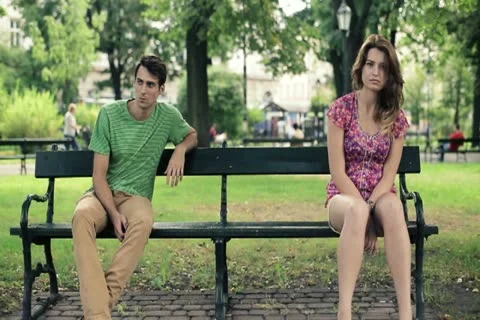 Relationship difficulties, couple sitting in park, steadicam shot NTSC Stock Footage 11819902